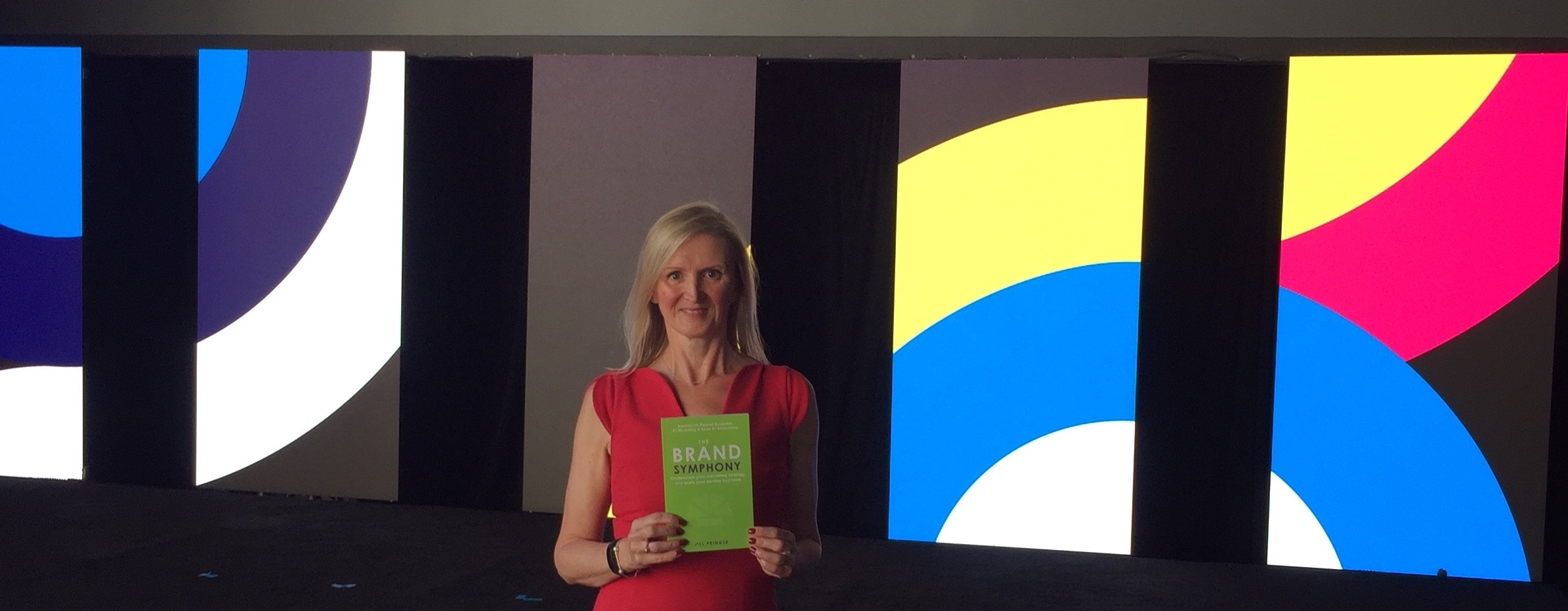 Jill Pringle holding The Brand Symphony Book